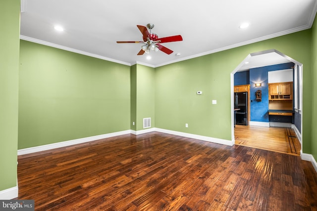 unfurnished room featuring visible vents, arched walkways, baseboards, ceiling fan, and wood-type flooring