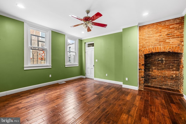 unfurnished living room featuring crown molding, visible vents, brick wall, wood finished floors, and baseboards