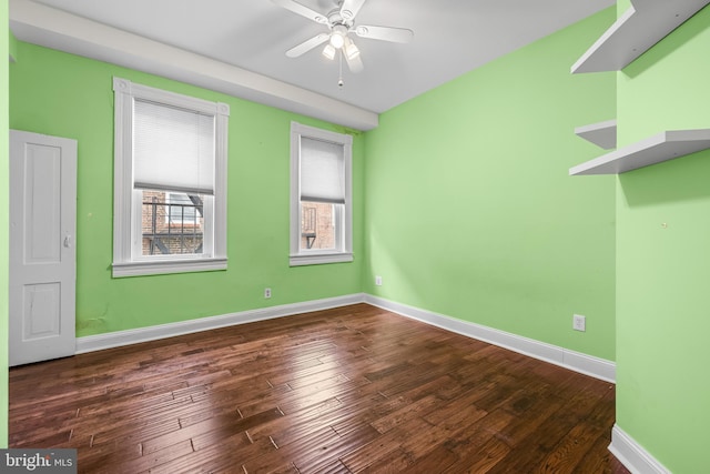 empty room featuring wood finished floors, a ceiling fan, and baseboards