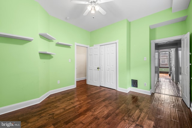 unfurnished bedroom featuring a closet, visible vents, a ceiling fan, wood finished floors, and baseboards