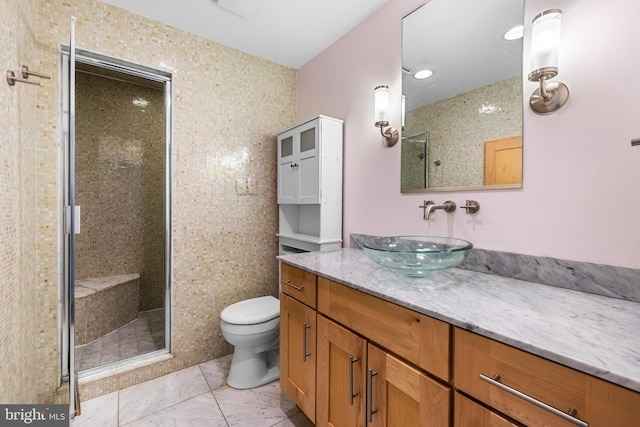 full bath with a stall shower, vanity, and toilet