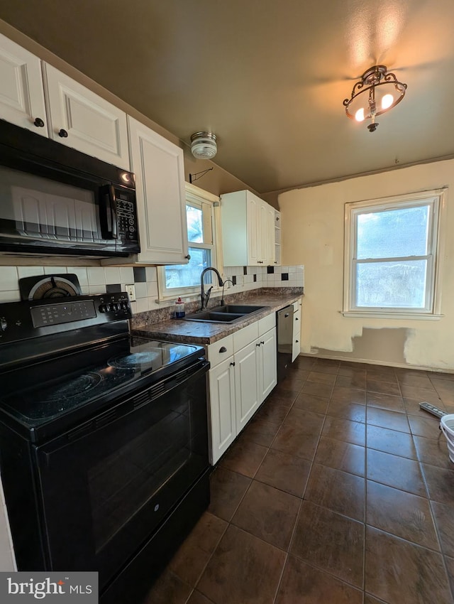 kitchen featuring sink, black appliances, white cabinets, dark tile patterned flooring, and decorative backsplash