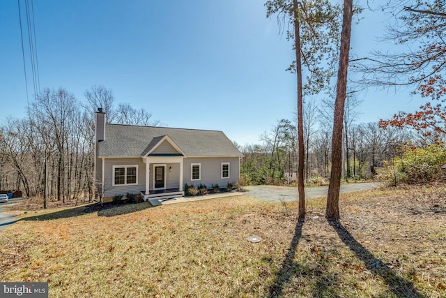 view of front of house featuring a chimney and a front lawn