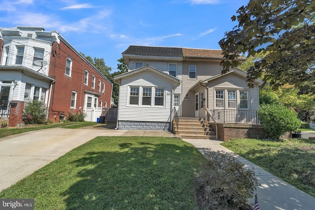 view of front of home featuring a shingled roof and a front yard