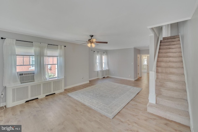 interior space with ceiling fan, light hardwood / wood-style flooring, radiator, and a healthy amount of sunlight