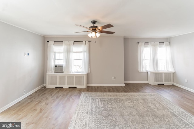 spare room featuring radiator, light hardwood / wood-style floors, and crown molding