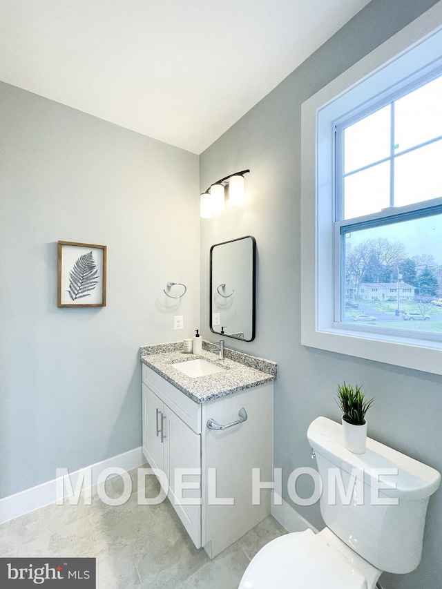 bathroom with toilet, vanity, and tile patterned flooring