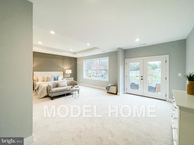 carpeted bedroom with french doors, access to exterior, multiple windows, and a raised ceiling