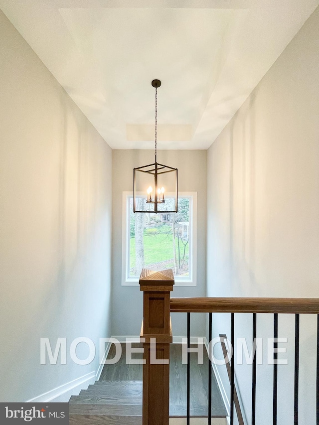 staircase with hardwood / wood-style flooring and an inviting chandelier