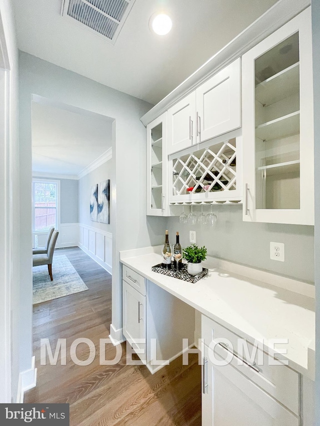 bar with white cabinetry and light hardwood / wood-style flooring