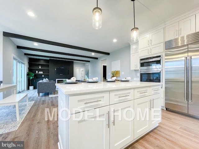 kitchen with white cabinetry, appliances with stainless steel finishes, and beam ceiling