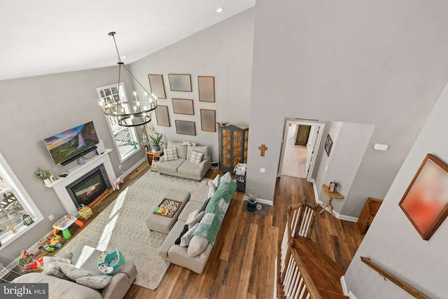 living room with high vaulted ceiling, dark hardwood / wood-style floors, and a chandelier