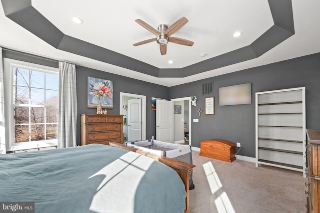 carpeted bedroom with a tray ceiling