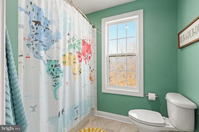 bathroom with toilet and a shower with curtain