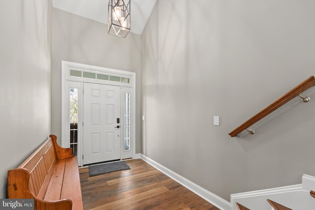 entrance foyer with a towering ceiling, a chandelier, and dark hardwood / wood-style flooring