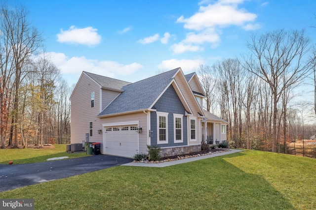 view of front of property featuring a garage, a front yard, and cooling unit