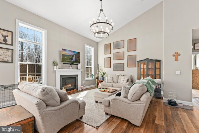 living room with high vaulted ceiling, hardwood / wood-style floors, and a notable chandelier