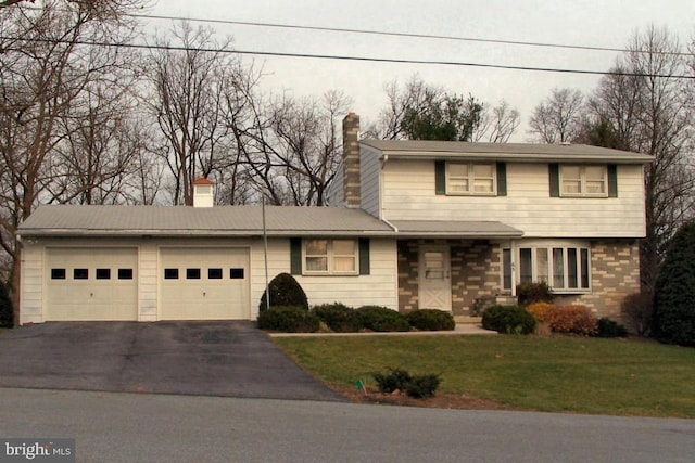 view of front of home with aphalt driveway, an attached garage, brick siding, a chimney, and a front yard