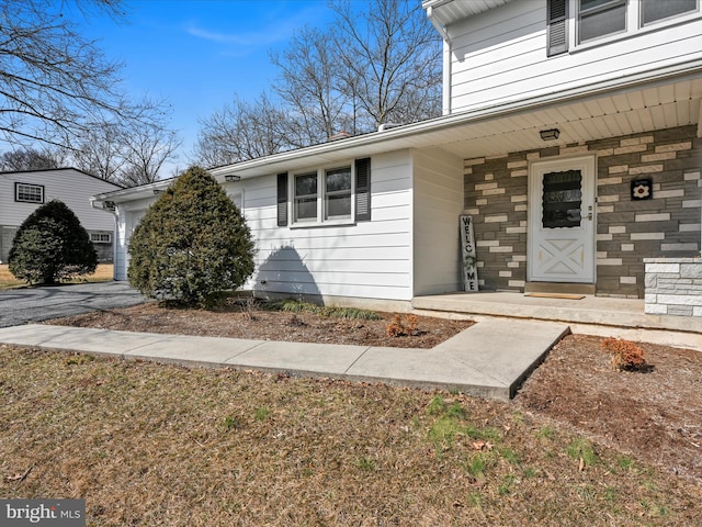 property entrance with stone siding and a porch