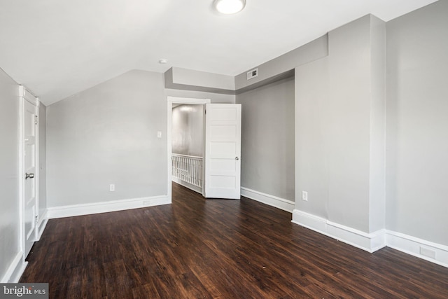 interior space with vaulted ceiling and dark wood-type flooring