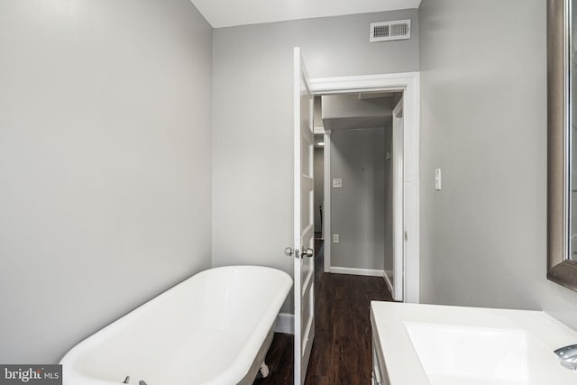 bathroom with hardwood / wood-style flooring, a bath, and vanity