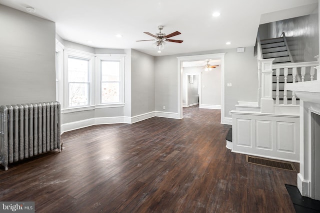 unfurnished living room featuring radiator heating unit, dark wood-type flooring, and ceiling fan