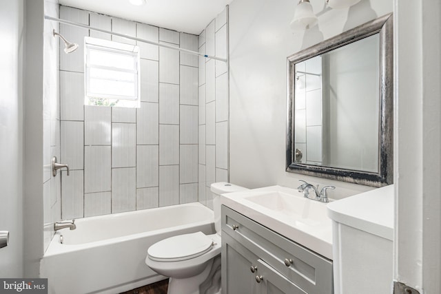 full bathroom with tiled shower / bath combo, vanity, and toilet