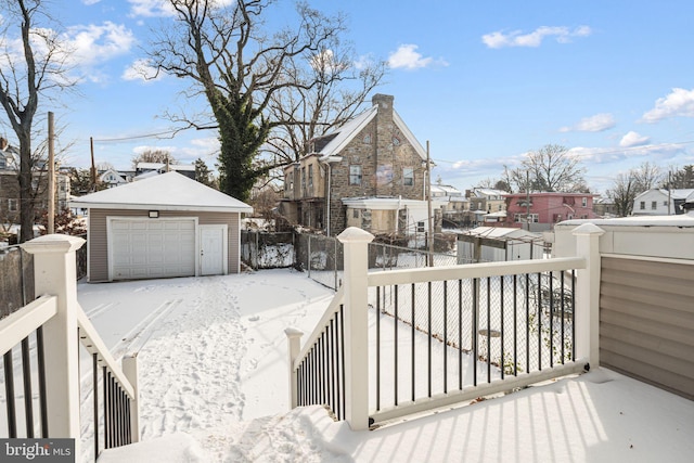 snow covered deck featuring a garage and an outdoor structure