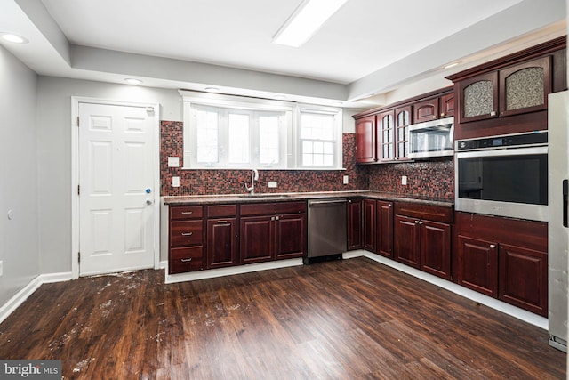 kitchen featuring sink, stainless steel appliances, dark wood-type flooring, and backsplash