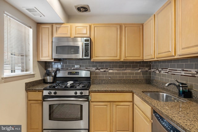 kitchen with sink, tasteful backsplash, light brown cabinetry, and appliances with stainless steel finishes