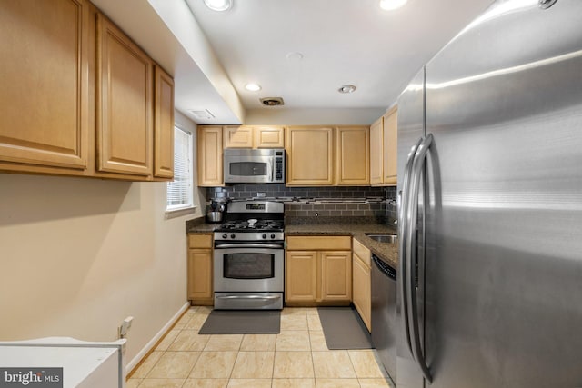 kitchen with light brown cabinets, appliances with stainless steel finishes, tasteful backsplash, and light tile patterned flooring