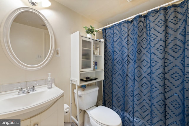 bathroom with toilet, walk in shower, and vanity