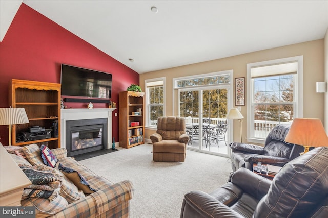 living room with plenty of natural light, vaulted ceiling, and carpet