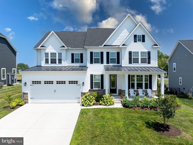 view of front of property with a garage, covered porch, and a front yard