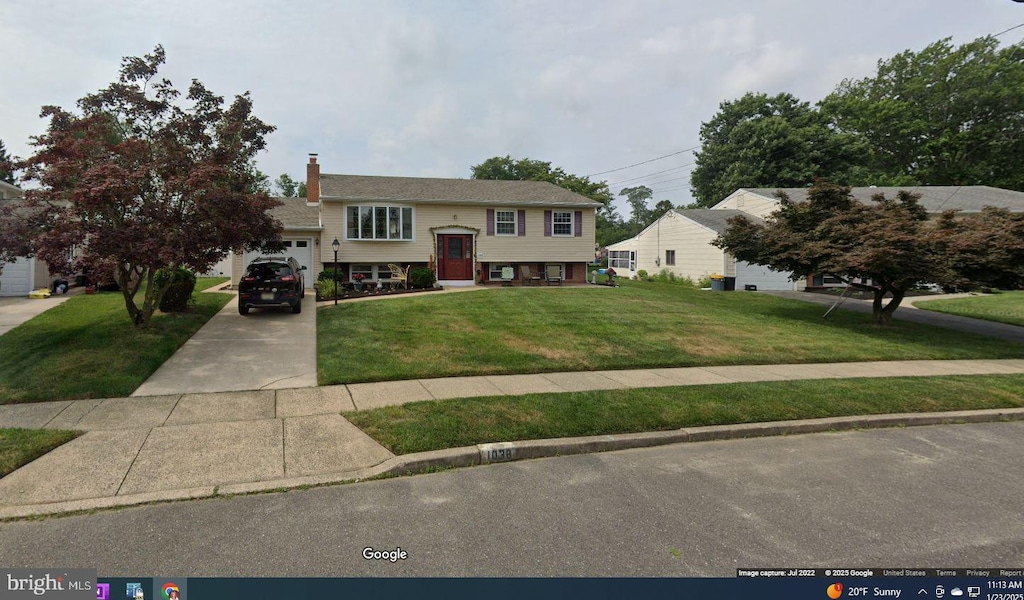 bi-level home with a garage and a front yard