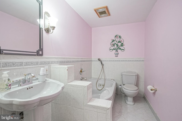 bathroom featuring sink, tile walls, tile patterned flooring, toilet, and a bath