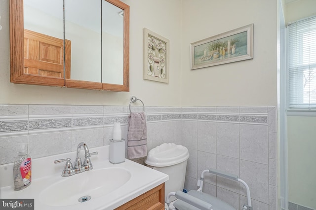 bathroom with vanity, toilet, and tile walls