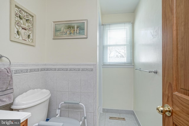 bathroom with vanity, tile walls, tile patterned floors, and toilet