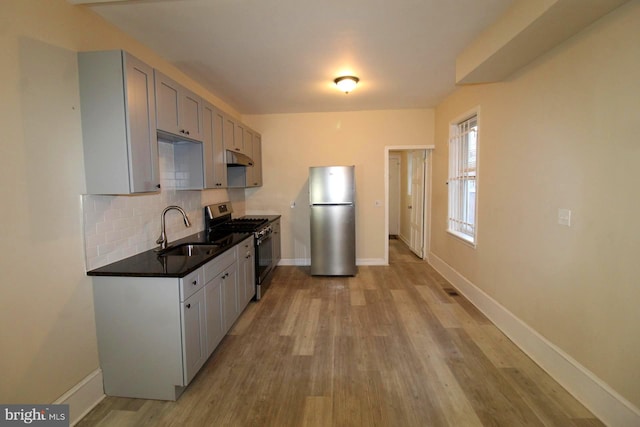 kitchen with gray cabinetry, sink, light hardwood / wood-style flooring, and stainless steel appliances