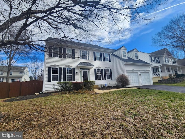 view of front of house with aphalt driveway, an attached garage, a front lawn, and fence