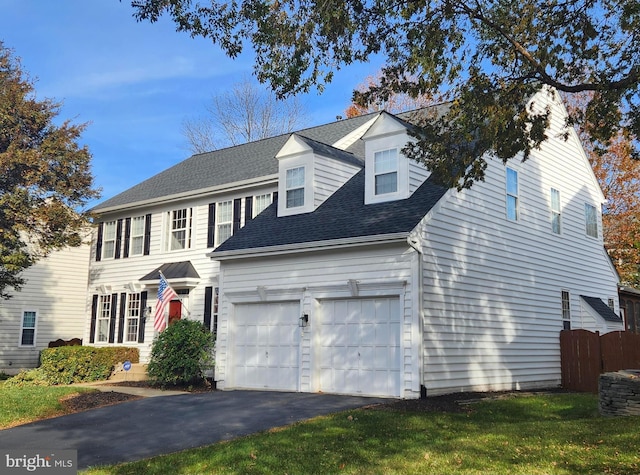 view of front of property with a front lawn, aphalt driveway, fence, roof with shingles, and a garage