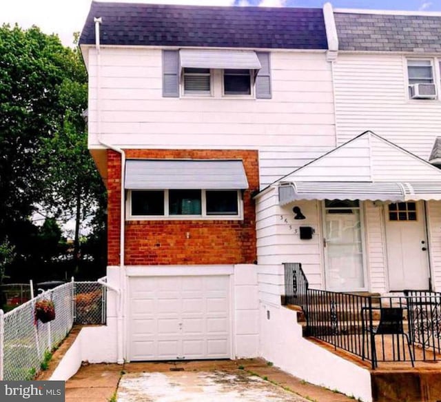 view of front of property with cooling unit and a garage