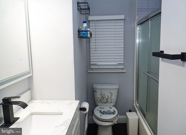 full bathroom with vanity, shower / bath combination with glass door, and toilet