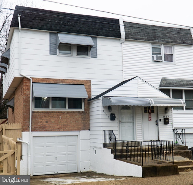 view of front of home with a garage and cooling unit