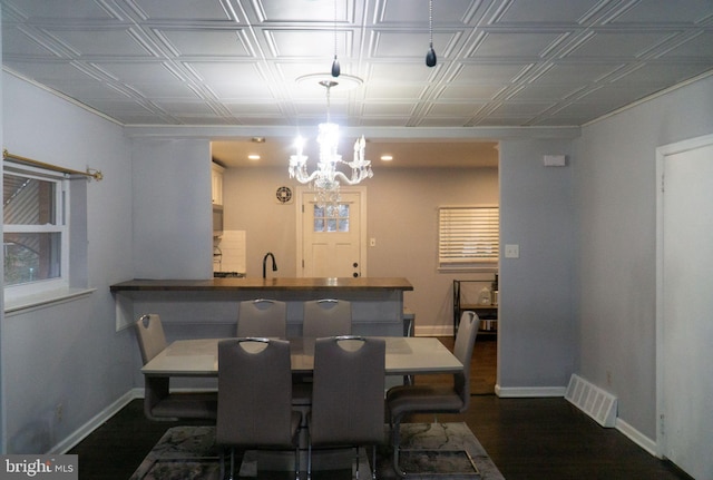 dining room featuring sink, a chandelier, and dark hardwood / wood-style flooring