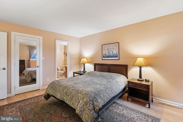 bedroom with wood-type flooring and connected bathroom