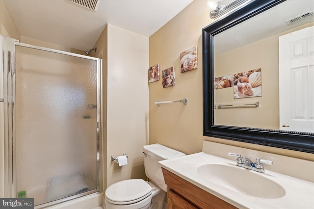 bathroom featuring vanity, toilet, and a shower with shower door