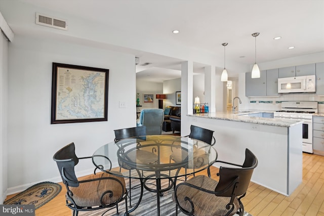 dining room featuring sink and light hardwood / wood-style floors