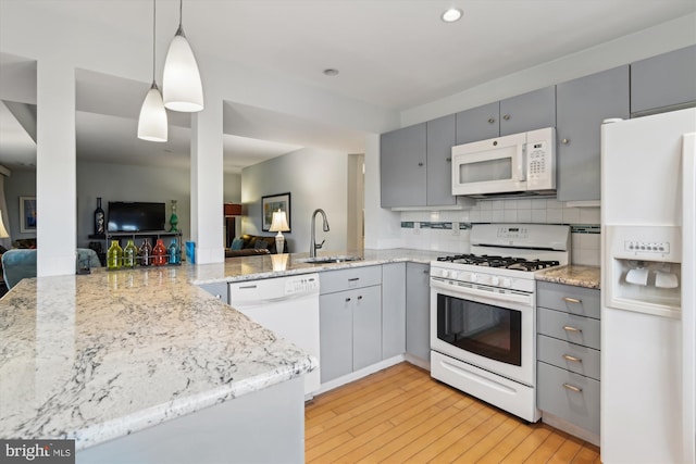 kitchen with gray cabinets, decorative light fixtures, sink, kitchen peninsula, and white appliances