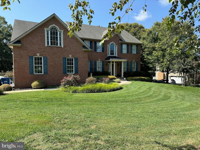 colonial inspired home with a front lawn